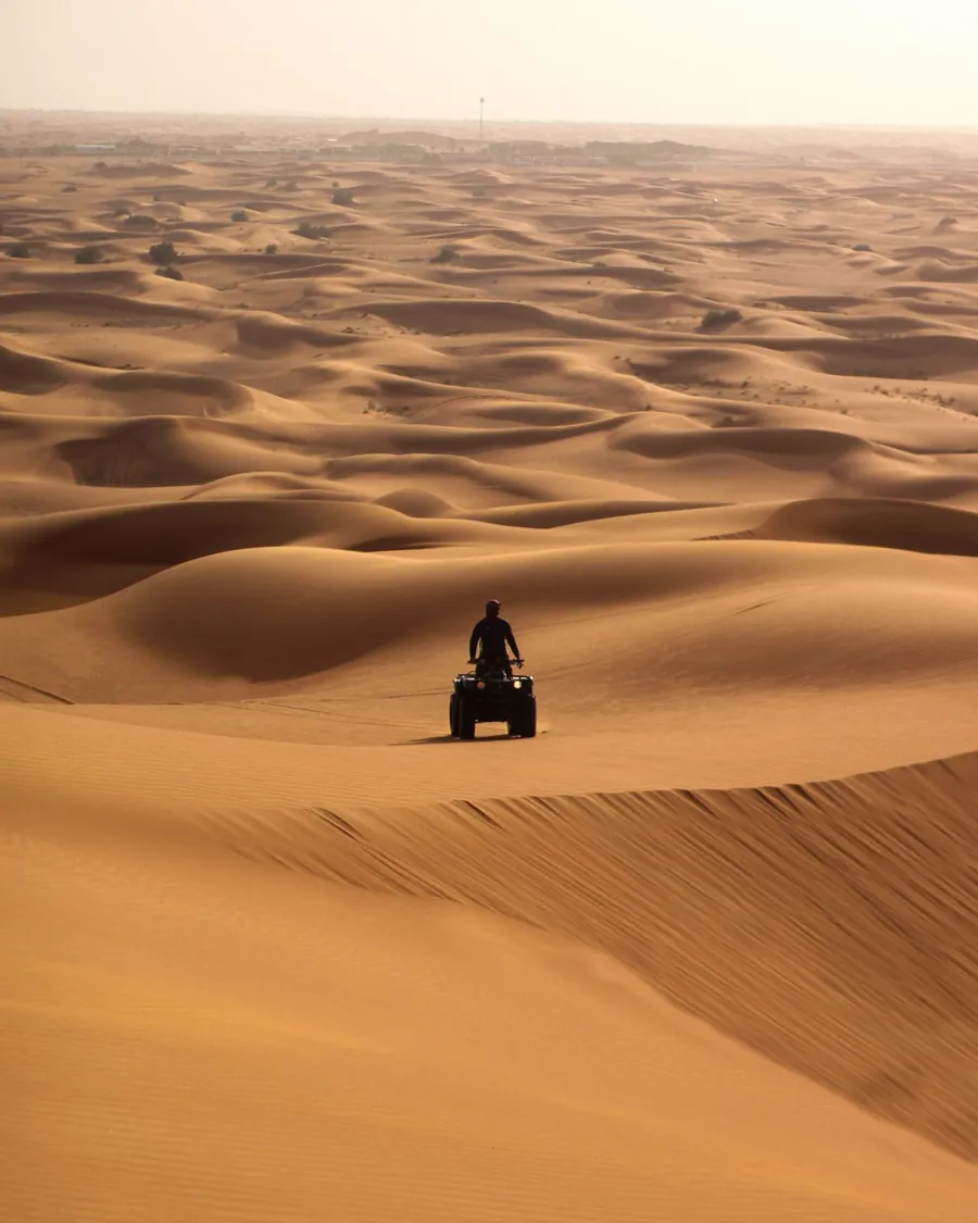 A rider on a quad bike looking out over the dunes of Erg Chebbi