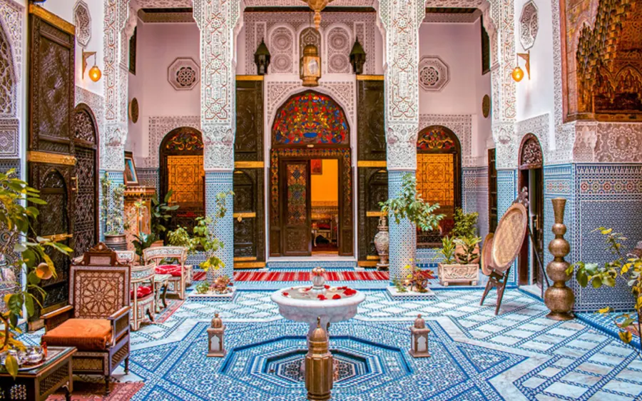 The courtyard of a traditional riad, with fountain, zellige tiles and carved arches