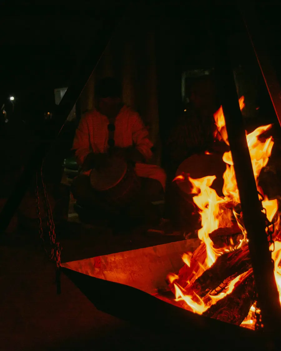 A campfire burning in the desert camp at night