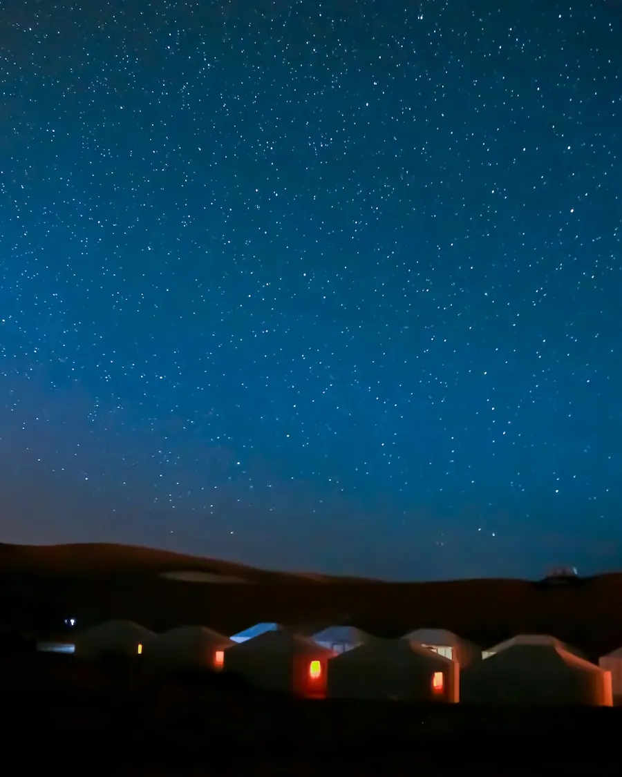 A sky full of stars above a desert camp in the Sahara
