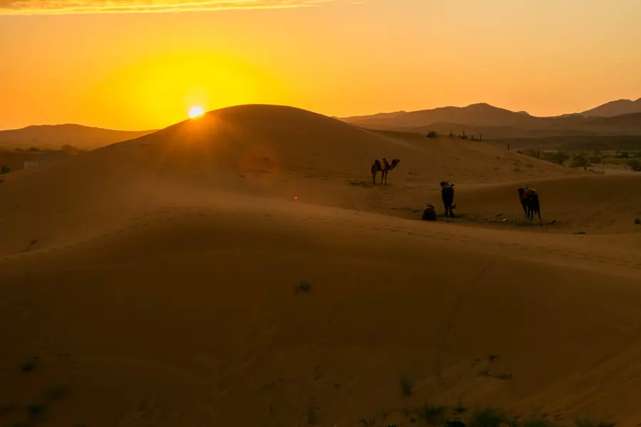 The sun setting behind the dunes of Merzouga