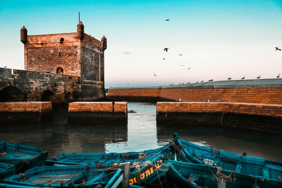 The harbour fort and fishing boats of Essaouira at dusk