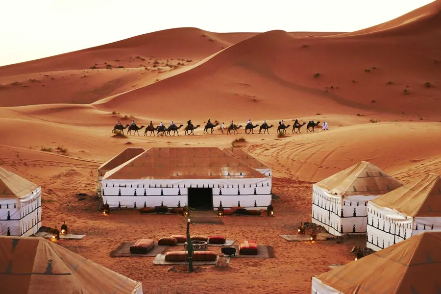 Tented desert camp among the Zagora dunes at golden hour